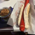red hotdog with bowl of onion flakes